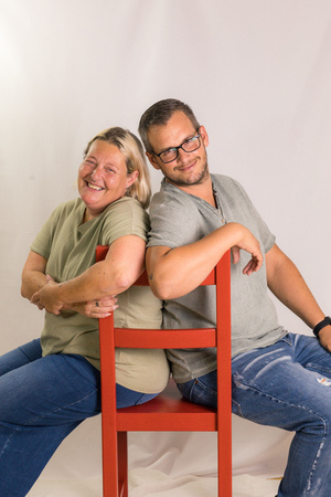 Ricarda und Gerald Lenzenwenger sitzen gemeinsam Rücken an Rücken auf einem Sessel.