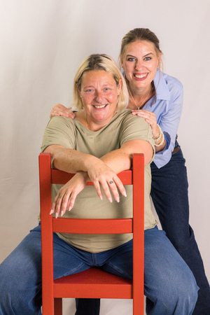 Ricarda Lenzenwenger sitzt auf einem roten Sessel und Kathrin Sandtner-Friess steht dahinter und hält sie an den Schultern fest.